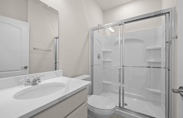 bathroom featuring walk in shower, vanity, and toilet