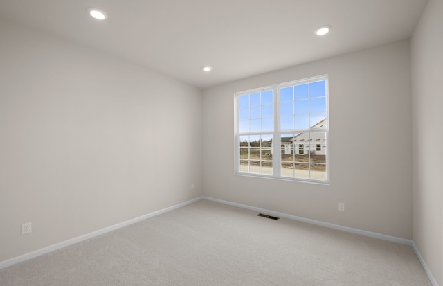 carpeted empty room featuring visible vents, baseboards, and recessed lighting