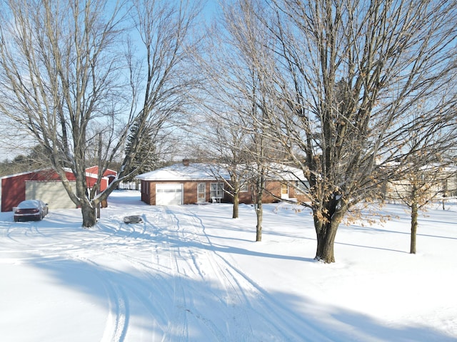 yard layered in snow featuring a garage