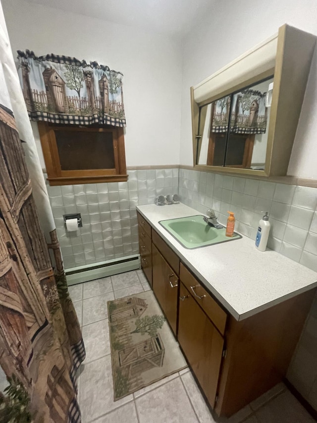 bathroom featuring vanity, a baseboard radiator, tile patterned flooring, and tile walls