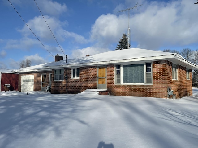 snow covered property featuring a garage