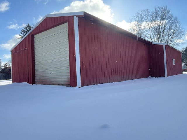 snow covered structure featuring a garage