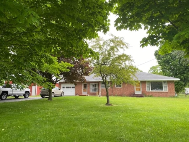 ranch-style house with a garage and a front lawn