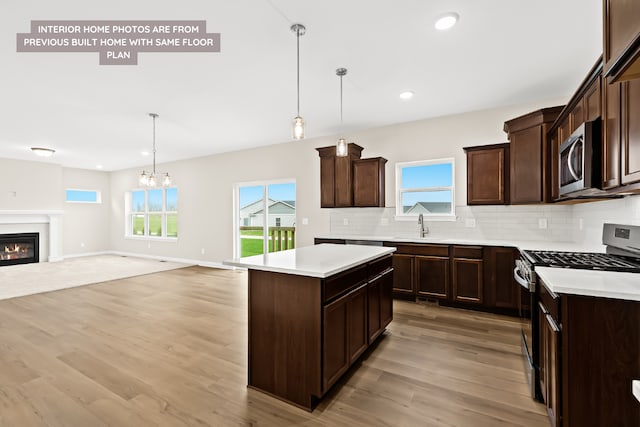 kitchen with stainless steel appliances, a chandelier, decorative light fixtures, and a kitchen island