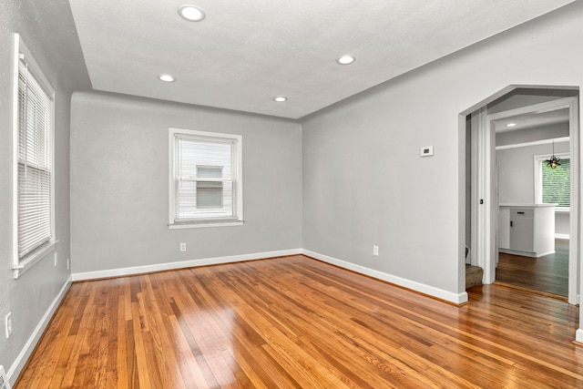 spare room with a textured ceiling and wood-type flooring