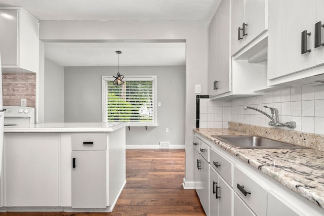 kitchen with white cabinets, pendant lighting, backsplash, and sink