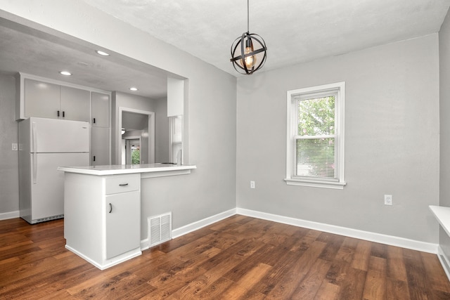 kitchen featuring kitchen peninsula, dark hardwood / wood-style floors, hanging light fixtures, a notable chandelier, and white refrigerator