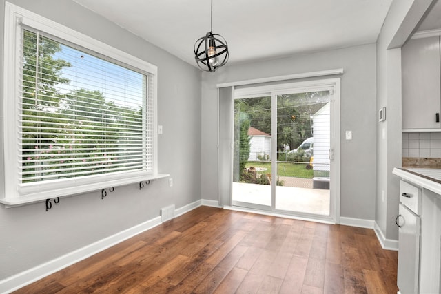 unfurnished dining area with dark hardwood / wood-style floors and plenty of natural light