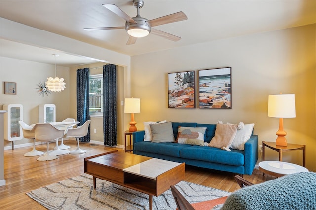 living room with ceiling fan and light wood-type flooring