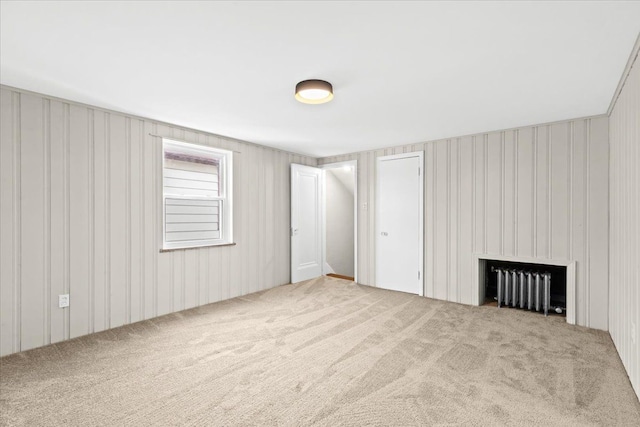 carpeted spare room with radiator heating unit