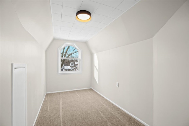 bonus room with light colored carpet and vaulted ceiling