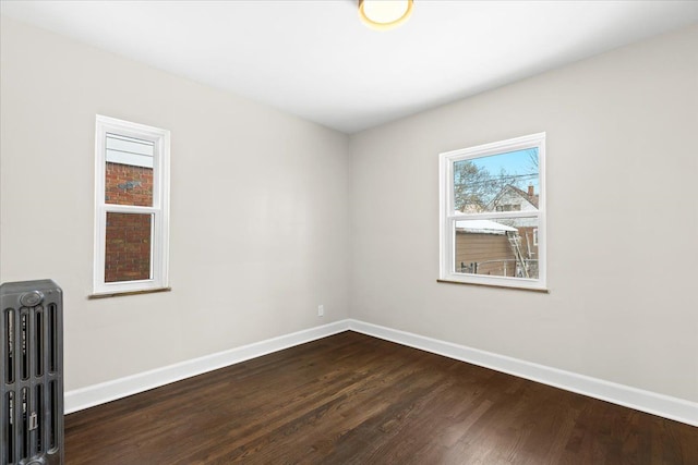 spare room with radiator heating unit and hardwood / wood-style flooring