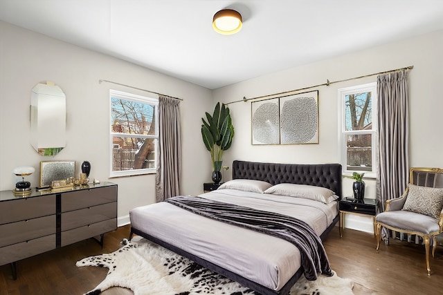 bedroom featuring multiple windows and dark wood-type flooring