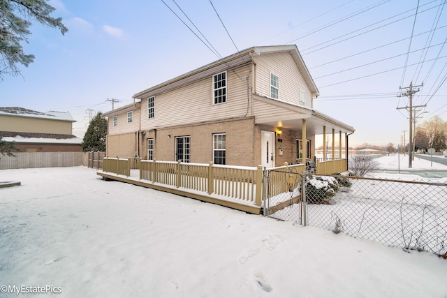 snow covered property with covered porch