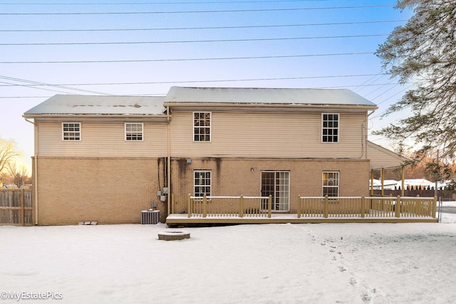 snow covered back of property featuring a wooden deck and cooling unit