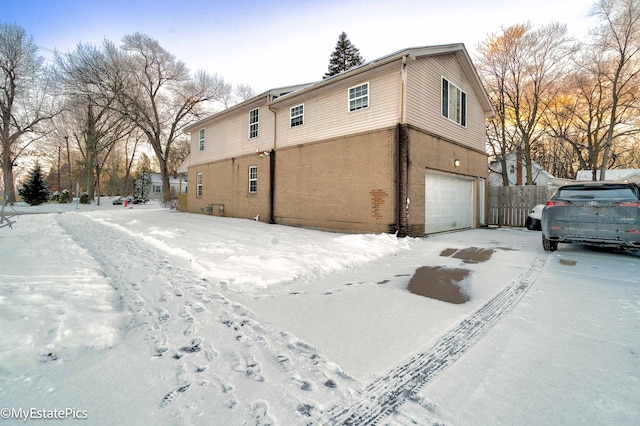 view of snowy exterior with a garage