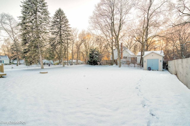 yard covered in snow featuring a storage shed