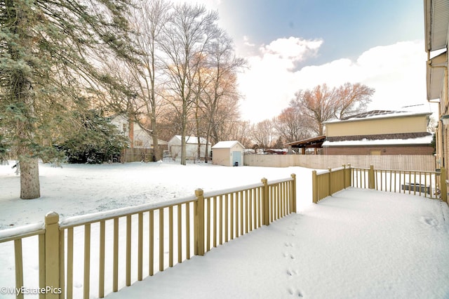 snow covered deck featuring a shed