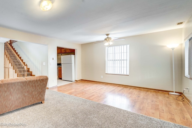 unfurnished living room featuring light hardwood / wood-style floors and ceiling fan