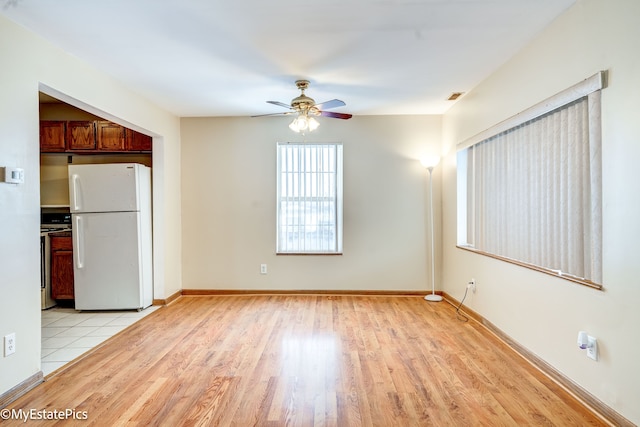 kitchen with ceiling fan, light hardwood / wood-style floors, stainless steel stove, and white refrigerator