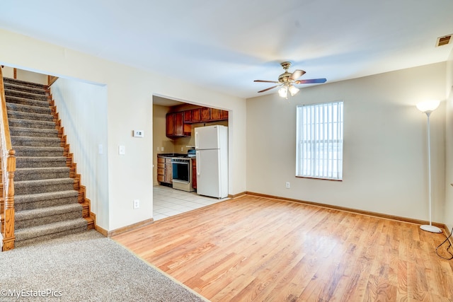 interior space featuring ceiling fan, light hardwood / wood-style floors, and white appliances