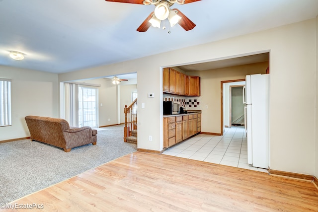 kitchen featuring ceiling fan, decorative backsplash, white refrigerator, and light hardwood / wood-style flooring