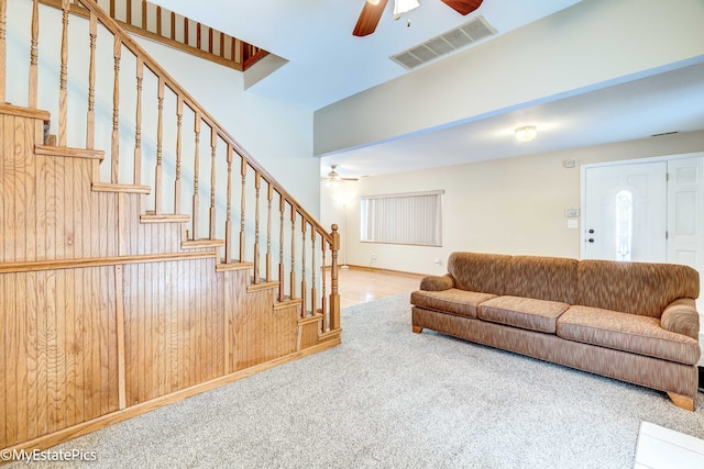 living room featuring ceiling fan, carpet, and wooden walls