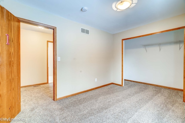 unfurnished bedroom with light carpet and a closet