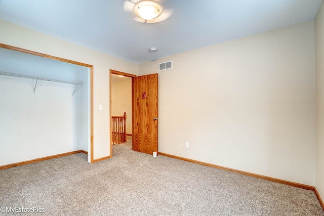 unfurnished bedroom featuring carpet and a closet