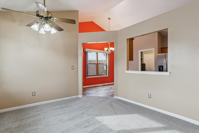 empty room featuring ceiling fan with notable chandelier, carpet floors, and lofted ceiling