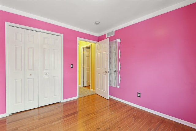 unfurnished bedroom featuring wood-type flooring and a closet