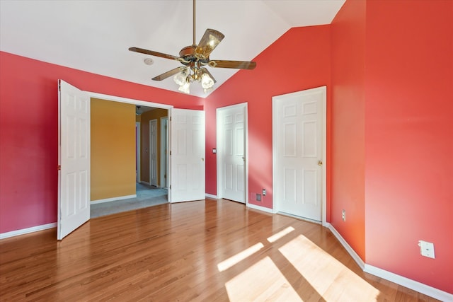 unfurnished bedroom featuring hardwood / wood-style flooring, high vaulted ceiling, and ceiling fan