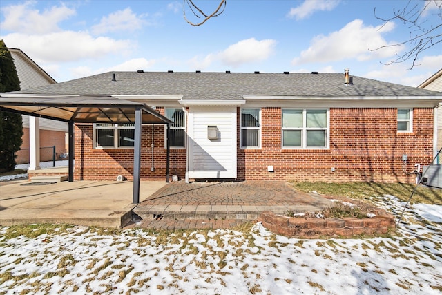 snow covered back of property featuring a gazebo and a patio