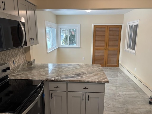 kitchen with gray cabinets, stainless steel appliances, light stone countertops, a baseboard radiator, and tasteful backsplash