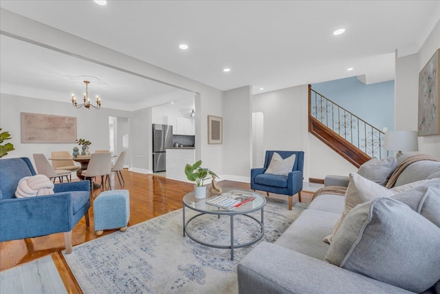 living room with an inviting chandelier and light hardwood / wood-style flooring