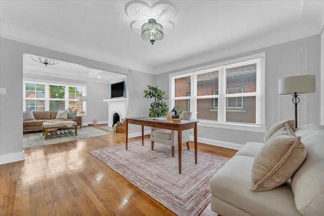 home office featuring an inviting chandelier, crown molding, and hardwood / wood-style floors