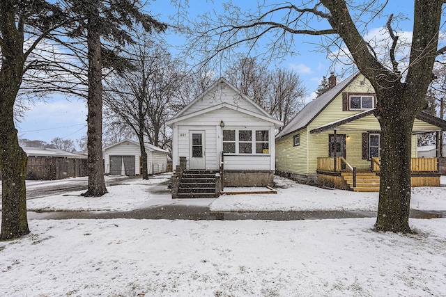 bungalow-style home with a garage and an outbuilding