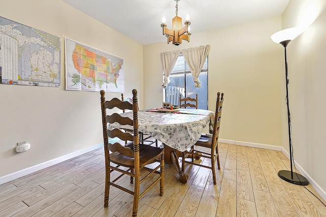 dining space featuring a notable chandelier and light wood-type flooring