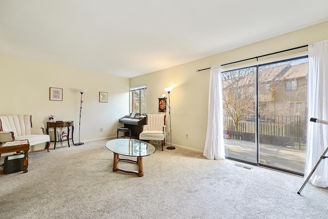 living area featuring a wealth of natural light and light carpet