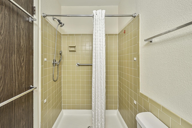 bathroom featuring toilet and curtained shower