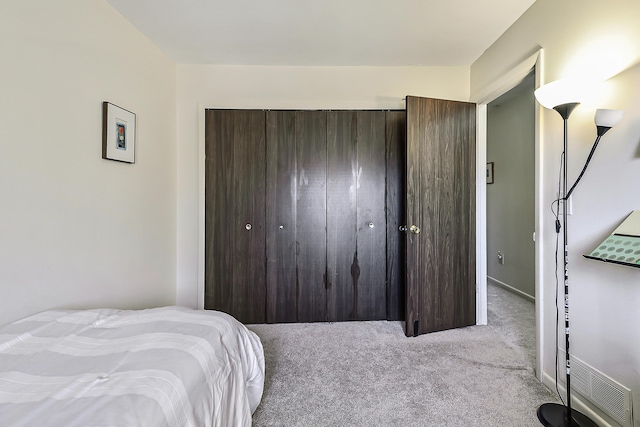 bedroom featuring a closet and light carpet