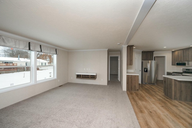 unfurnished living room featuring a textured ceiling, crown molding, and heating unit