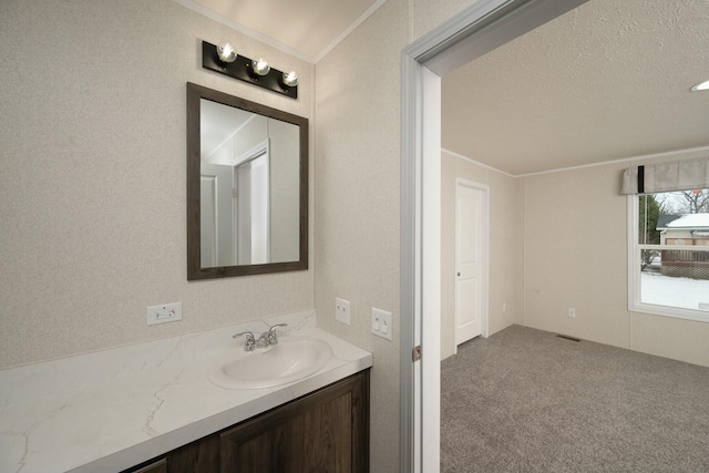 bathroom featuring a textured ceiling, ornamental molding, and vanity