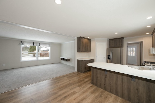 kitchen featuring light colored carpet, stainless steel fridge with ice dispenser, a healthy amount of sunlight, and sink