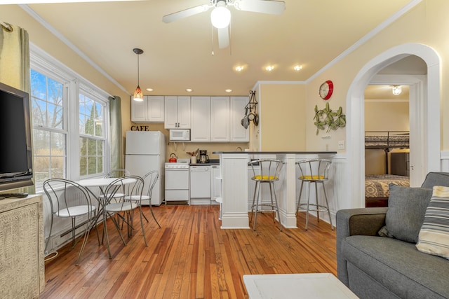 kitchen featuring decorative light fixtures, white cabinetry, white appliances, light wood-type flooring, and ceiling fan