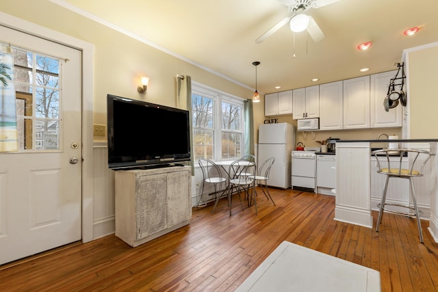 kitchen with dark hardwood / wood-style flooring, white appliances, white cabinetry, and ceiling fan