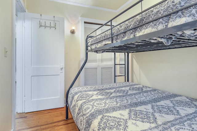 bedroom with crown molding and hardwood / wood-style flooring