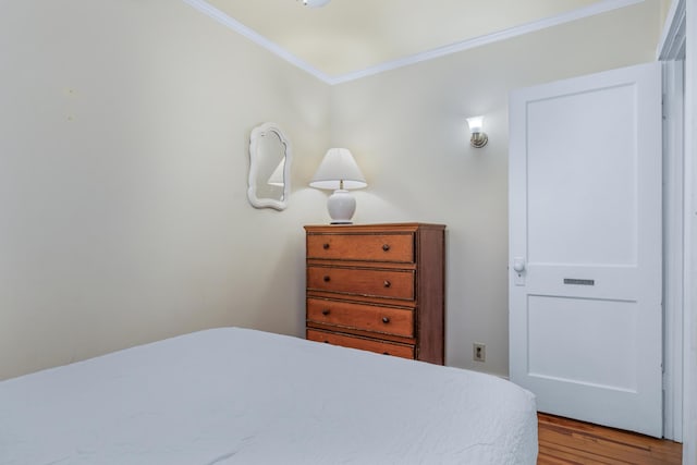 bedroom with ornamental molding and light wood-type flooring