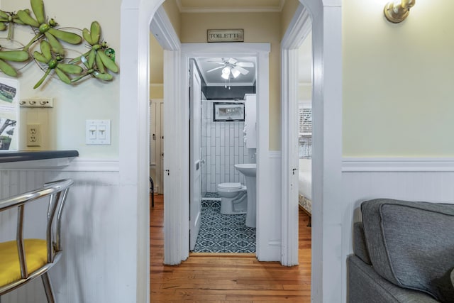 hall with ornamental molding and wood-type flooring