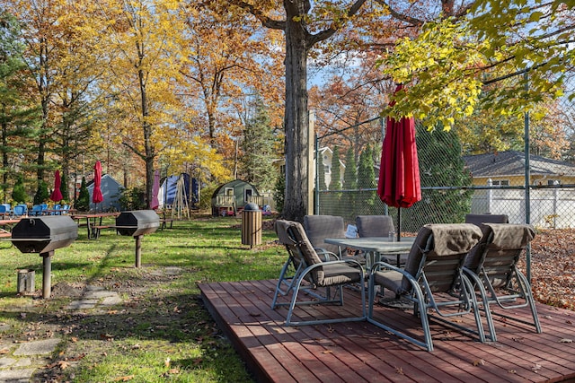 wooden terrace featuring a yard and a grill